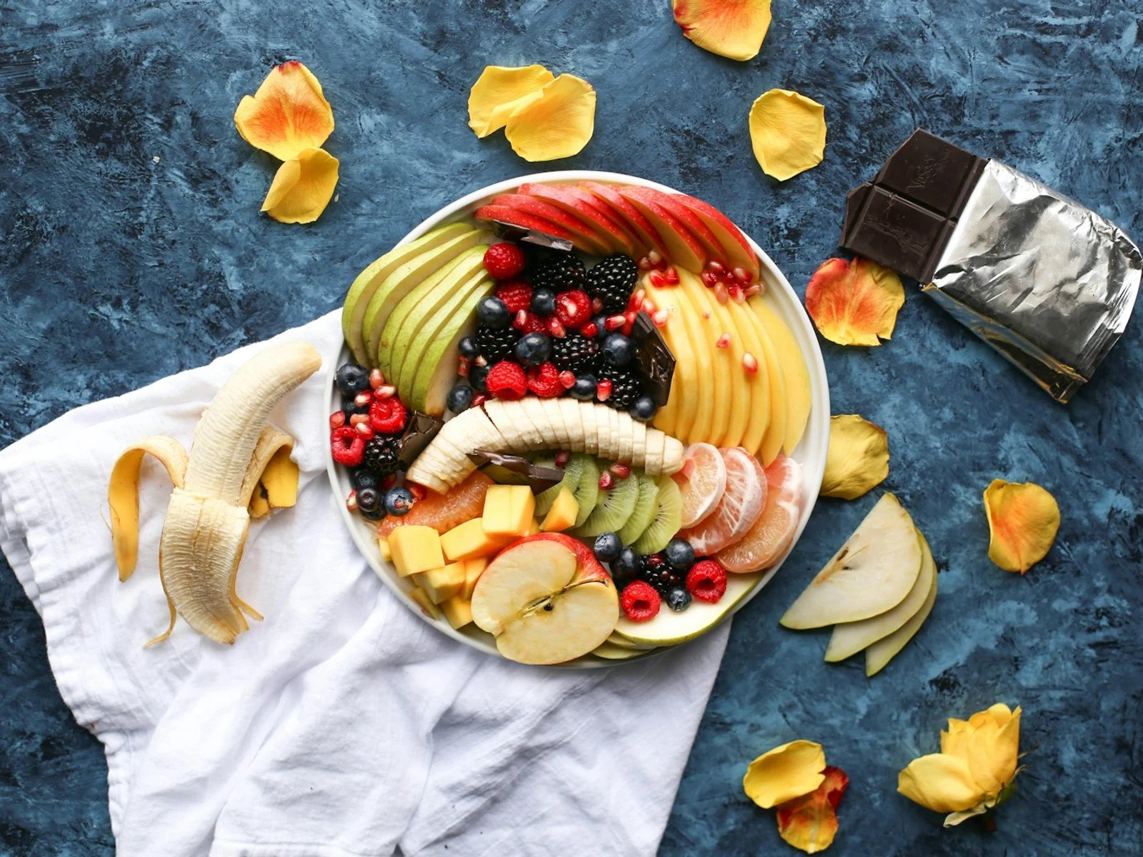 Fruit mix made with chopped pieces of red and green apples, mandarin orange segments, fresh strawberry slices, and blueberries.